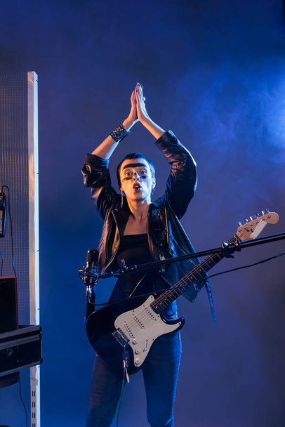 Важкий метал-художник плескає руками і виконує живий рок-виступ з альтернативною музикою. Створення вібе і прохолодна фанк атмосфера, співати пісні з гітарою і носити шкіряний піджак
. - Фото, зображення