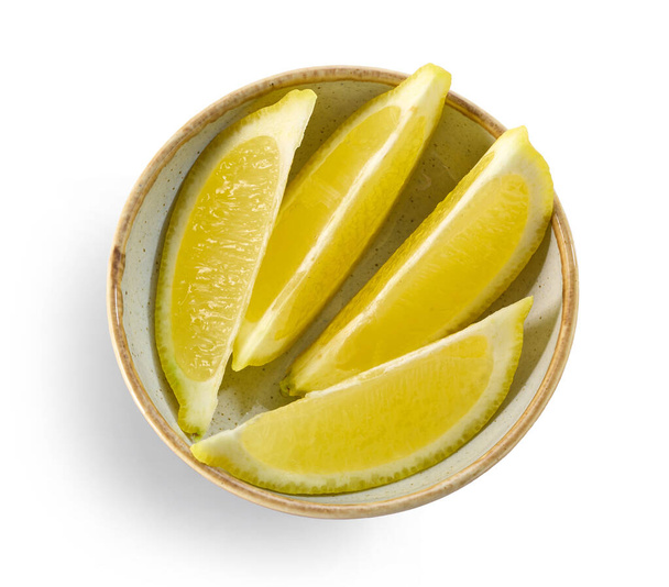 Schüssel mit frischen Zitronenscheiben isoliert auf weißem Hintergrund, Draufsicht - Foto, Bild