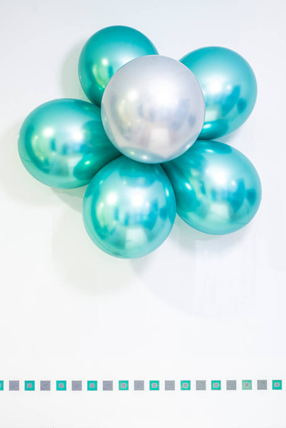 flor feita de balões de hélio em cores metálicas verde e prata, sobre um fundo branco, espaço de cópia, verde e prata quadrados valance, vertical - Foto, Imagem