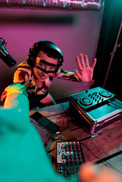 Femme artiste DJ mixant des sons sur des platines tournantes, en utilisant des boutons et une touche basse pour mélanger de la musique techno. Musicien se produisant avec mélangeur à la boîte de nuit, en utilisant le panneau de commande électrique, disc jockey. - Photo, image