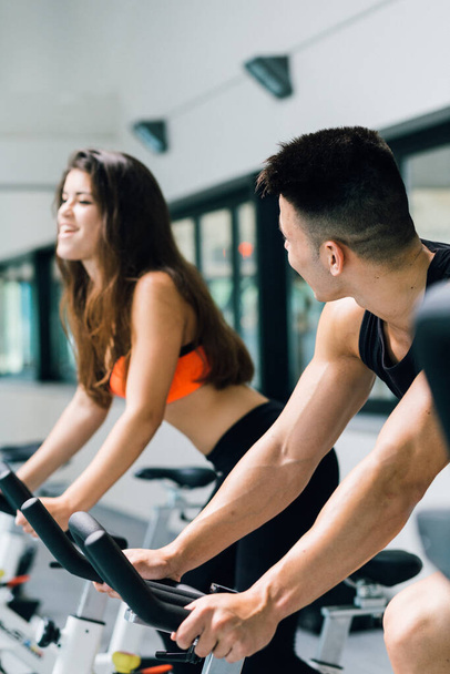 A young couple on cycling machine working out together - Foto, Bild
