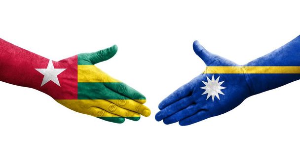 Kädenpuristus käsiin maalattujen Naurun ja Togon lippujen välillä, eristetty läpinäkyvä kuva. - Valokuva, kuva