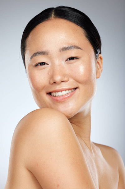 Beauty, asian and skincare with portrait of woman and smile for spa, cosmetics and clean wellness. Happy, makeup and facial treatment with girl for luxury, health and model in gray background studio. - Fotografie, Obrázek