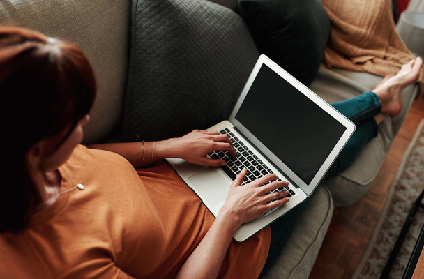 Reach out to me through my website. an unrecognizable woman using her laptop at home - Foto, imagen