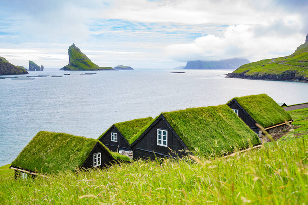 Cuadro de pueblo con caseta de techo de hierba tradicional y paisaje de fiordos. Vagar, Islas Feroe. - Foto, imagen