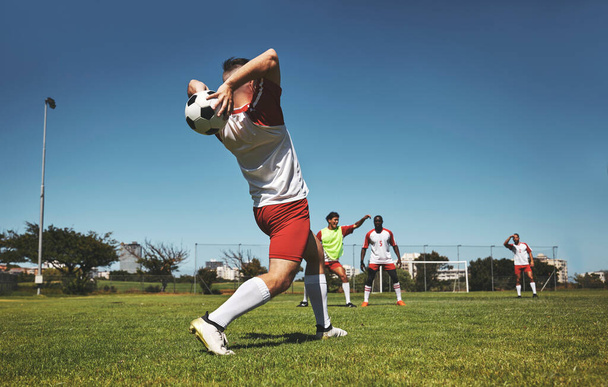 Football throw and field game of a team in a fitness, exercise and sports match outdoor. Training, soccer workout and athlete teamwork collaboration ready for cardio together in the summer sun. - Photo, Image