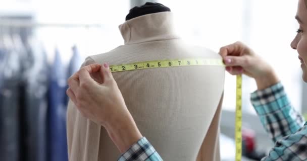 Seamstress takes measurements from clothes on mannequin. Tailoring in hotel concept - Footage, Video