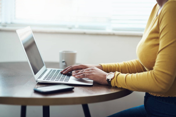 Ich blogge gerne. eine unkenntliche Frau, die allein zu Hause sitzt und ihren Laptop benutzt - Foto, Bild