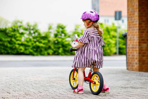Pequena menina criança correndo com bicicleta de equilíbrio no dia de verão. Condução infantil feliz, ciclismo com bicicleta, atividade ao ar livre. Felicidade, infância. - Foto, Imagem