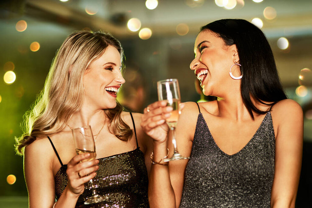 Możemy być wiecznie młodzi. dwie wesołe młode kobiety pijące drinki podczas tańca na parkiecie klubu w nocy - Zdjęcie, obraz