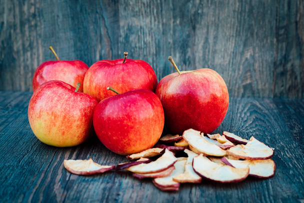 リンゴ、乾燥したリンゴ、バラの腰は暗い木製のテーブルの秋にあります。高品質の写真 - 写真・画像
