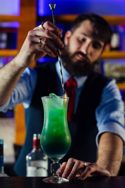 Close up of barman decorate blue lagoon cocktail - Fotó, kép