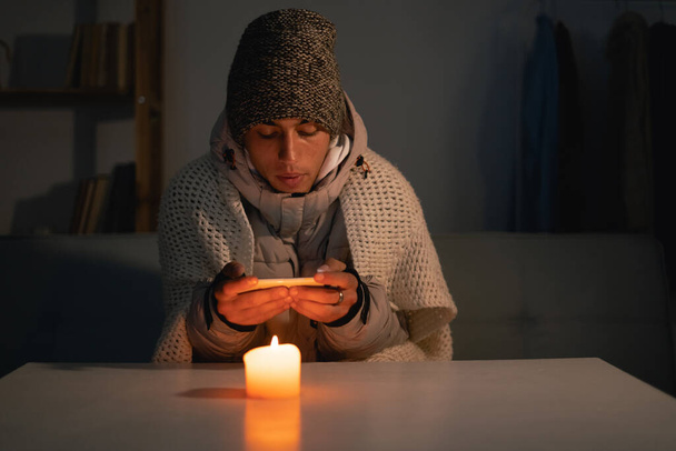 Müder Mann leidet ohne Heizung und Strom während einer Energiekrise in Europa, die Stromausfälle verursacht. Kopierraum. - Foto, Bild