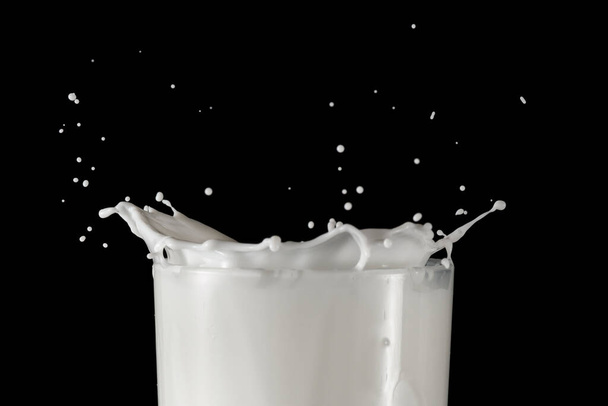 Egy pohár tejet fröccsenéssel. Egy pohár tejet feketére.. - Fotó, kép