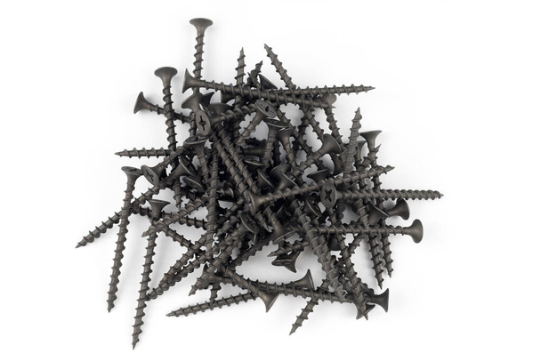 Screws on white. Pile of black tapping screws isolated on a white background. - Фото, зображення