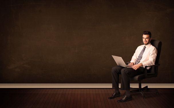 Businessman holding high tech laptop on background with copyspac - Valokuva, kuva
