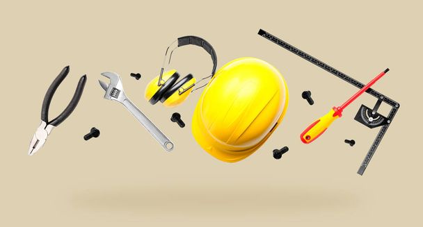 Builder's headphones with set of professional supplies on grey background - Photo, Image