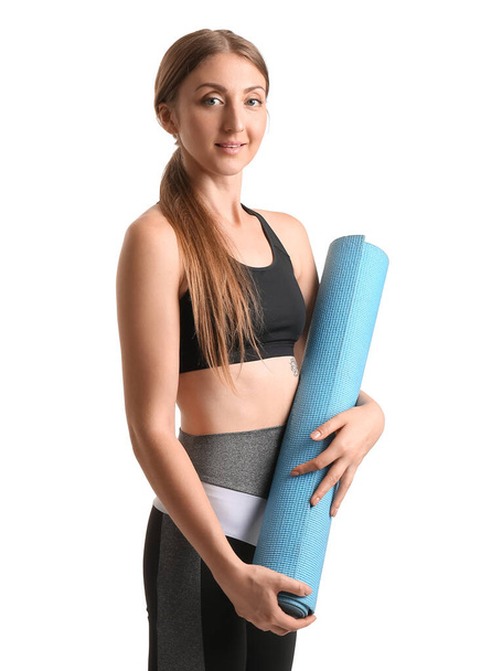 Sporty young woman with yoga mat on white background - Fotó, kép