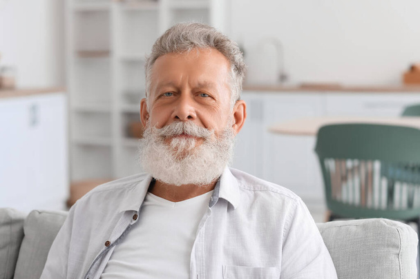 Senior bearded man sitting on sofa in kitchen, closeup - Photo, Image