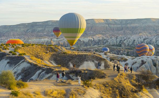 日の出の間に離陸し始め、多くの視聴者が壮大なショーを待っている気球の風光明媚な空中ショット。高品質の写真 - 写真・画像