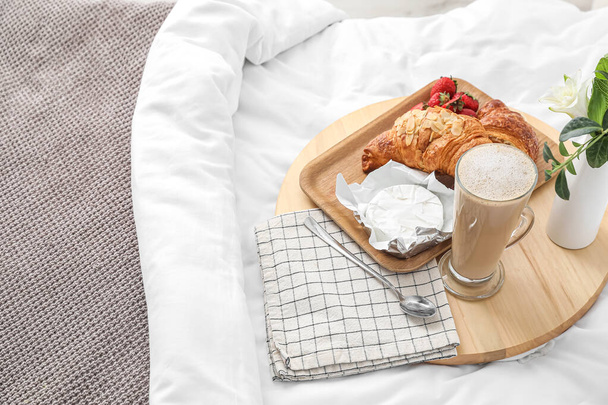 Tray with tasty breakfast and coffee on white blanket in bedroom - Zdjęcie, obraz