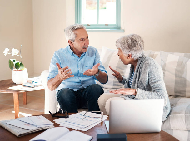Money can make a real mess of marriage. a senior couple having a disagreement while going through paperwork at home - Photo, image