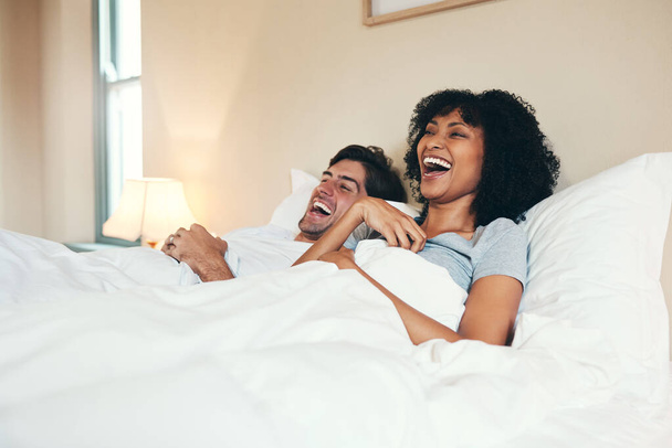 Наполняю комнату смехом. ласковая молодая пара проводит некоторое время вместе в своей спальне дома - Фото, изображение