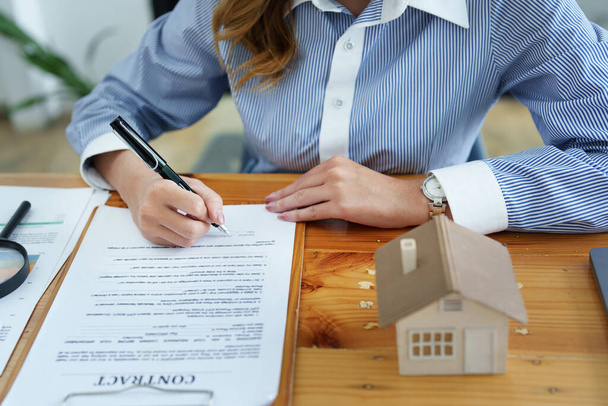 Bürgschaft, Hypothek, Vereinbarung, Vertrag, Unterzeichnung, Männlicher Kunde hält Stift zum Lesen des Vertragsdokuments, um Landdarlehen mit Immobilienmakler oder Bankangestelltem zu unterzeichnen - Foto, Bild