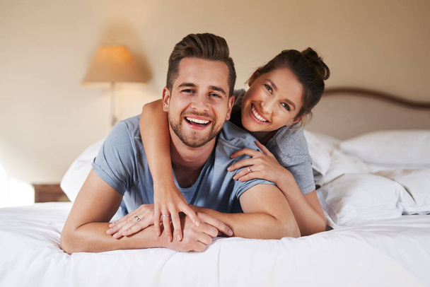 Todos sonreímos hoy. Retrato de una pareja joven y cariñosa pasando un tiempo de calidad juntos en su dormitorio en casa - Foto, imagen