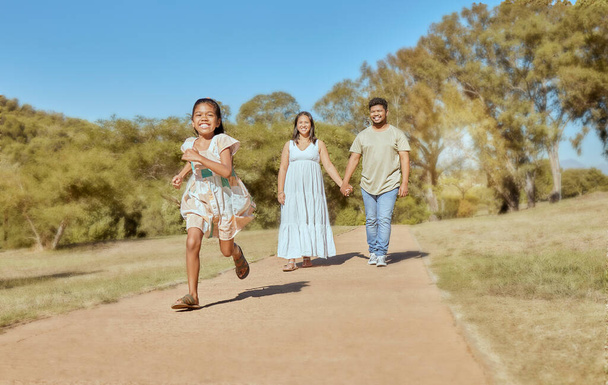 Family, park and together, nature and outdoor, parents holding hands and girl running, spending quality time outside. Mexican man, woman and child, fun in the sun and bonding, happy and summer - Photo, Image