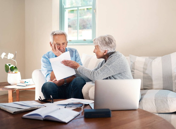 Финансовый стресс сказывается на их браке. пожилая пара, имеющая разногласия во время работы с бумагами дома - Фото, изображение
