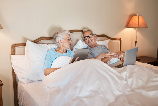 Dont you think this is a good picture. a senior couple sitting in bed together and using technology in a nursing home - 写真・画像