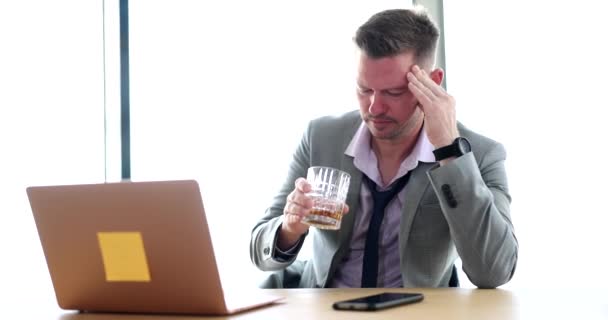 Hombre de negocios tenso y estresante sosteniendo un vaso de whisky en la oficina. Adicción al alcohol y concepto de hombre de negocios borracho - Metraje, vídeo
