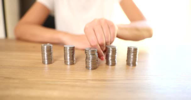 Een close-up van een zakenvrouw die een stapel zilveren munten verplaatst. Winstgevende financiële deposito 's of economische inflatie - Video