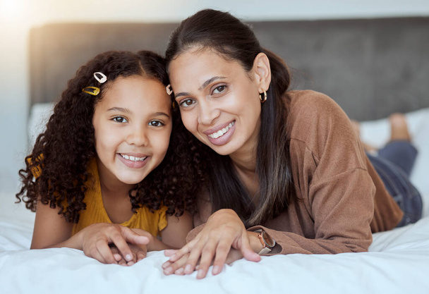 Mother, girl and happy family home morning on a bedroom bed feeling family love and care. Portrait of a mama and child in a house bonding together with a smile lying with happiness smiling content. - Fotoğraf, Görsel