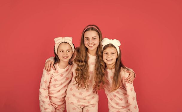 Homewear and pyjamas for girls. Happy sisters in homewear pink background. - Foto, Imagen