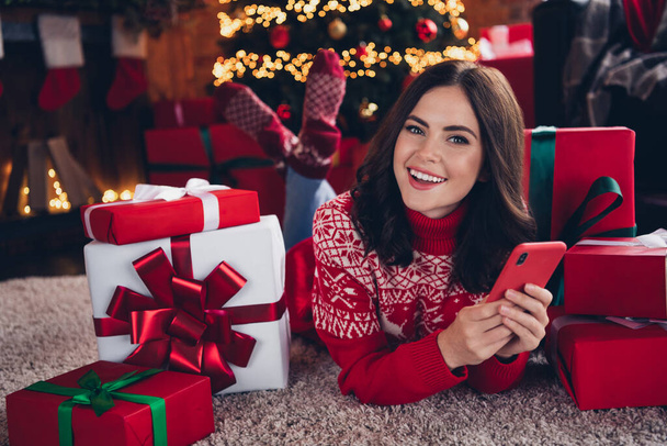 Portrait of attractive positive lady laying carpet floor use telephone pile stack giftbox dream miracle indoors. - Photo, Image