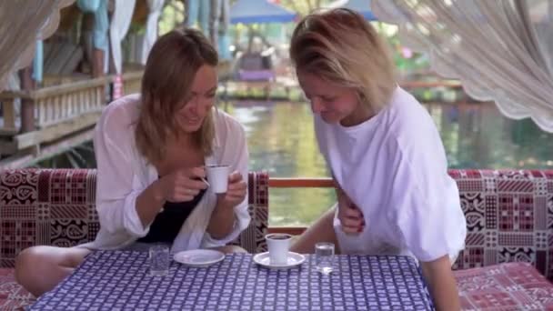 Encantadoras amigas toman café en un restaurante en las montañas de Turquía, mientras viajan en Alanya. - Imágenes, Vídeo