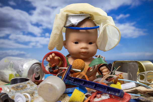 Dětská panenka obklopená odpadky a odpadky na krásné pláži  - Fotografie, Obrázek