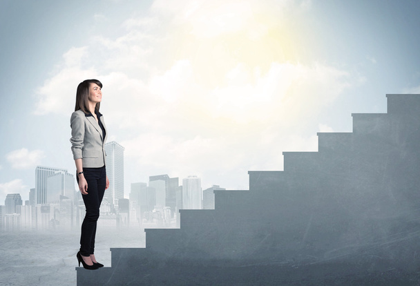 Businesswoman climbing up a concrete staircase concept - Photo, Image