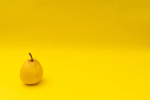 Yellow pears on a yellow background - Фото, изображение