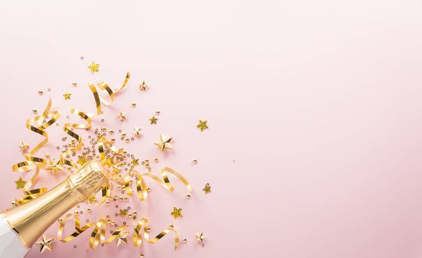 Ευτυχισμένος ο εορτασμός της Πρωτοχρονιάς. Σαμπάνια μπουκάλι, χρυσή κορδέλα, αστέρια και χριστουγεννιάτικη μπάλα σε παστέλ φόντο. - Φωτογραφία, εικόνα