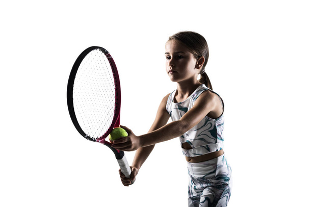 Young female tennis player silhouette. Little girl posing with racket and ball isolated on white background. - Foto, Imagen