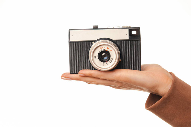 Close up of woman hand holding old vintage film camera over white background. - Фото, изображение