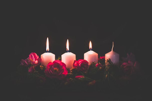 tercera vela de adviento ardiente en flor de rosa decorada corona de adviento rosa - Foto, imagen