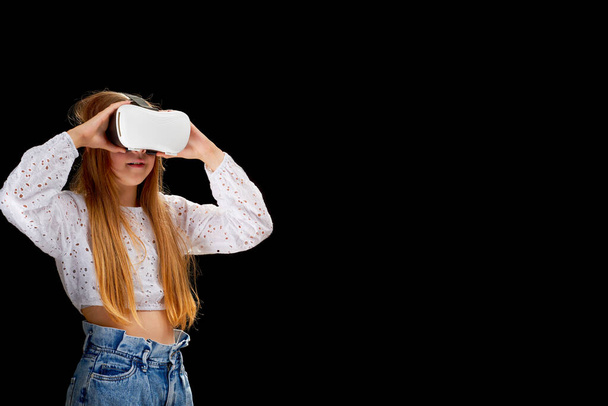 Портрет молодой белой женщины, использующей виртуальную реальность с голографическими голографическими очками, Google. Концепция технологии будущего на чёрном фоне. образование и игры в метавселенной. - Фото, изображение