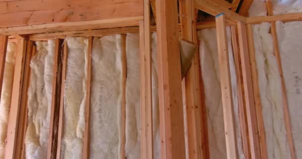 Installing interior thermal and sound insulation rockwool mineral fiber glass wool among beams framing for wall new home - Footage, Video