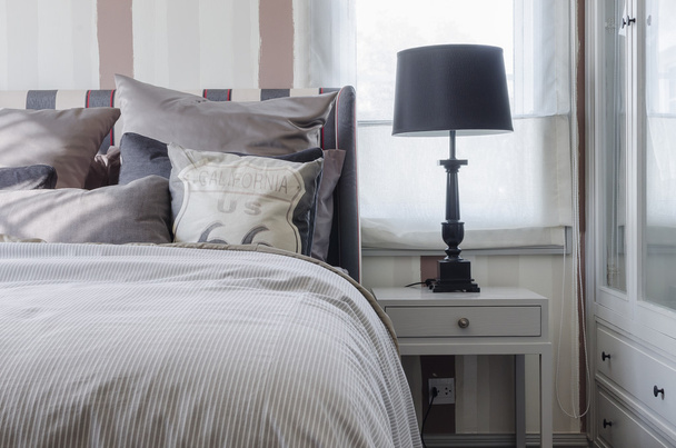 чорна лампа на сірому столі в спальні
  - Фото, зображення