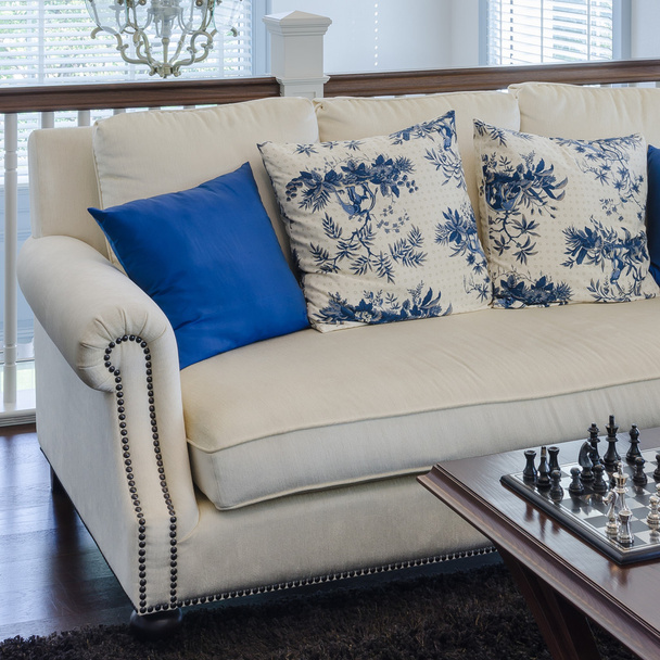 Καναπές πολυτέλειας με μπλε μαξιλάρι στο καφετί χαλί στο σαλόνι - Φωτογραφία, εικόνα