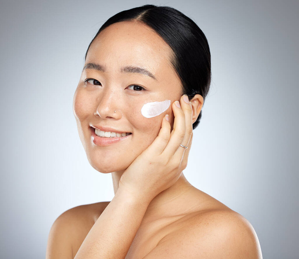 Woman, face cream or grooming skincare routine on studio background for Japanese facial, wellness or luxury healthcare. Zoom, smile or happy beauty model with spf sunscreen product for sun protection. - Фото, изображение